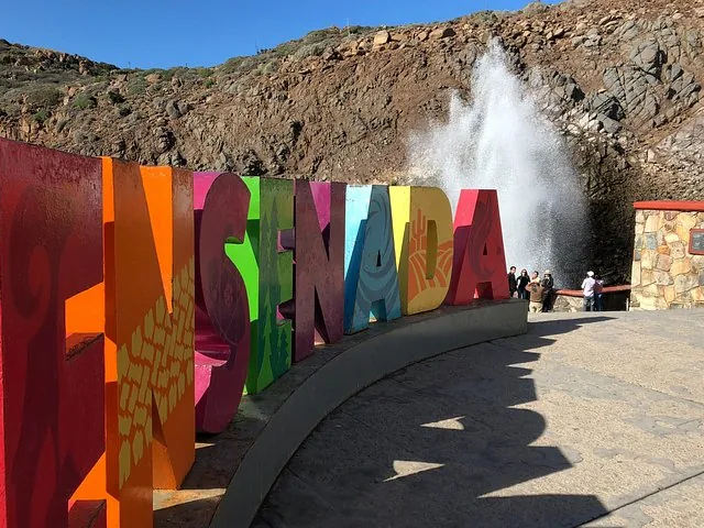 Großes buntes Ensenada-Schild mit einer Wasserfontäne im Hintergrund.