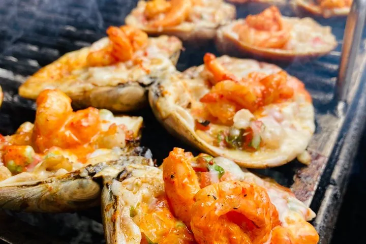 Grilled clam shells filled with a cooked seafood mixture.