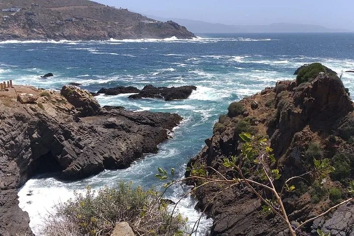Rocky coastline with splashing waves on a sunny day.
